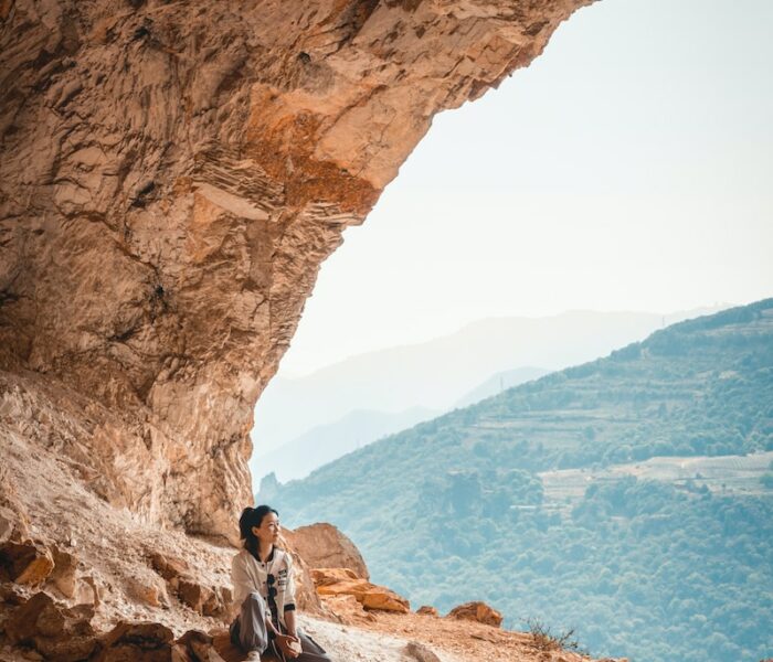 a man sitting on a rock in a cave