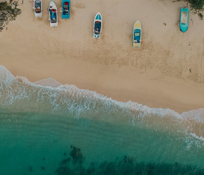 a group of boats sitting on top of a sandy beach