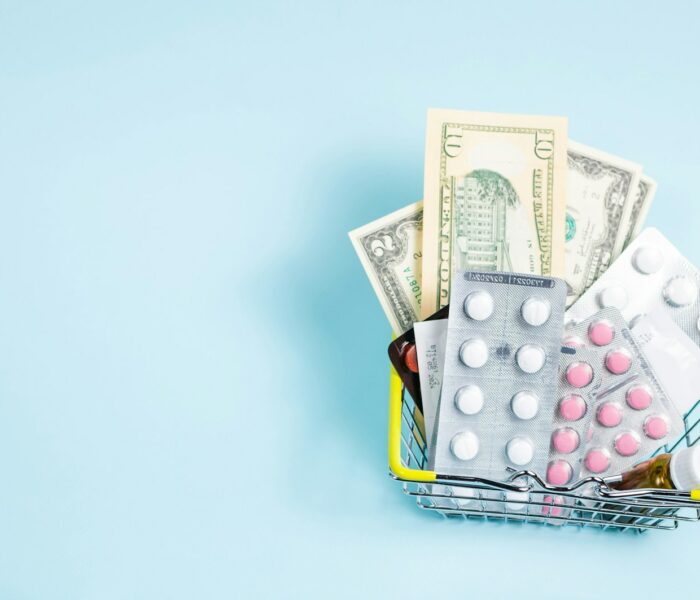 a shopping cart filled with pills and money