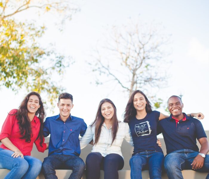 group of people sitting on bench near trees duting daytime